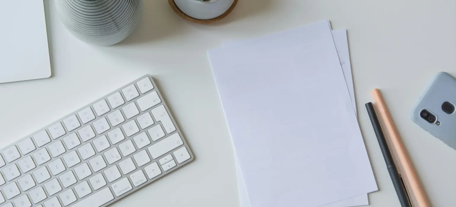 White printer paper beside white apple keyboard