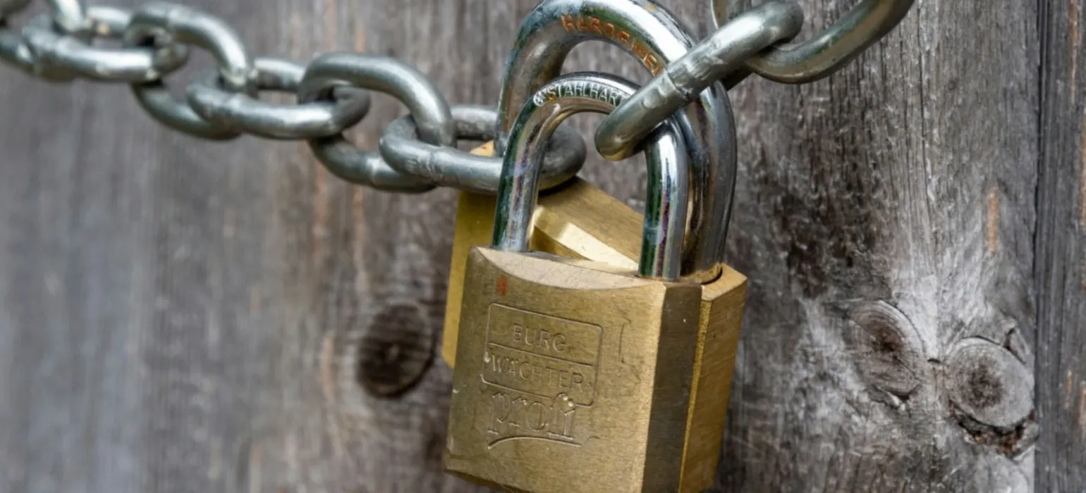 Brown padlock on brown wooden fence