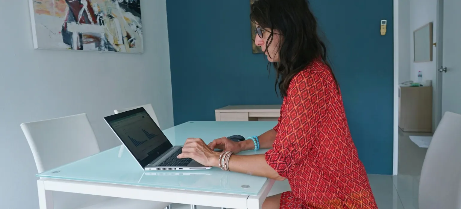 Woman works on laptop at a table