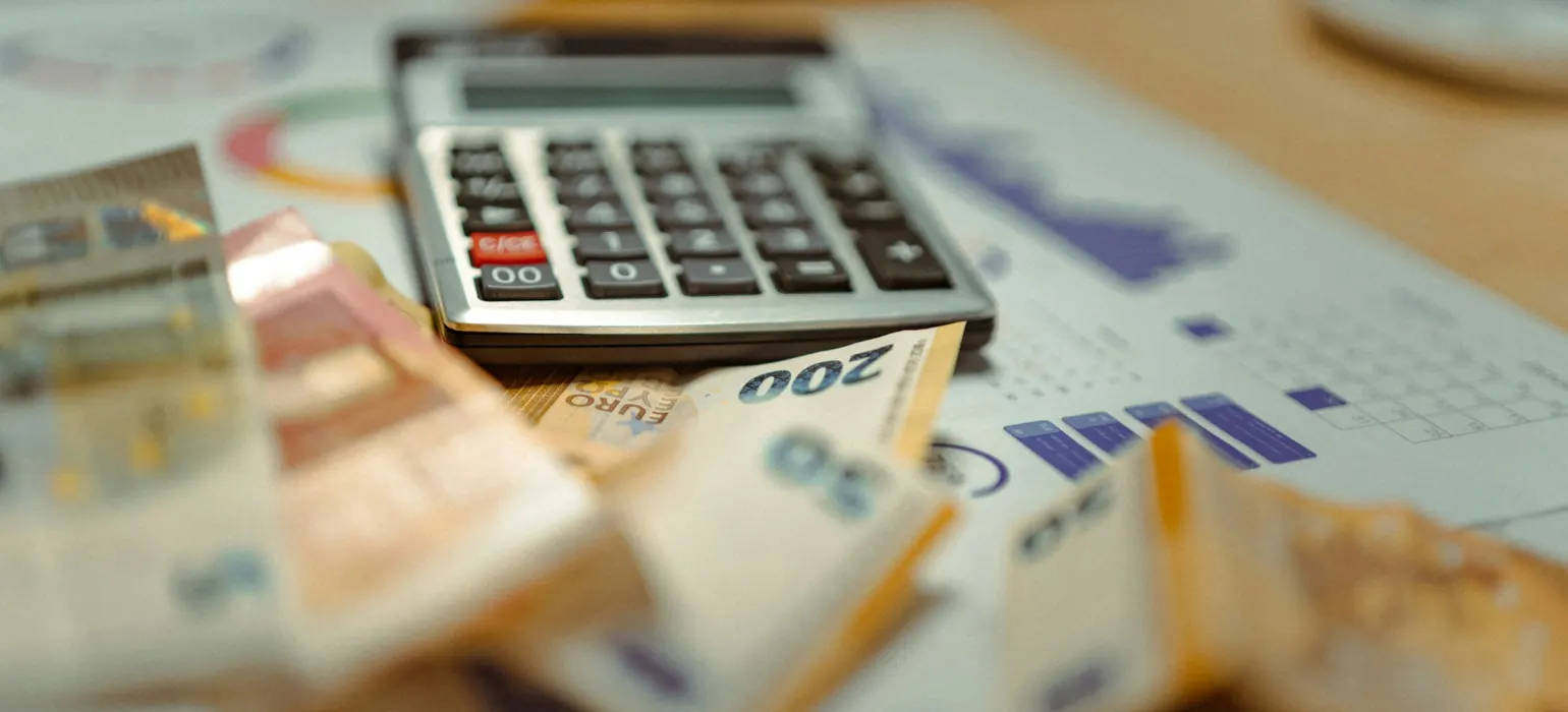 A calculator sitting on top of a pile of money