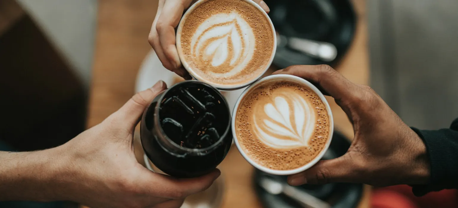 Three person holding beverage cups