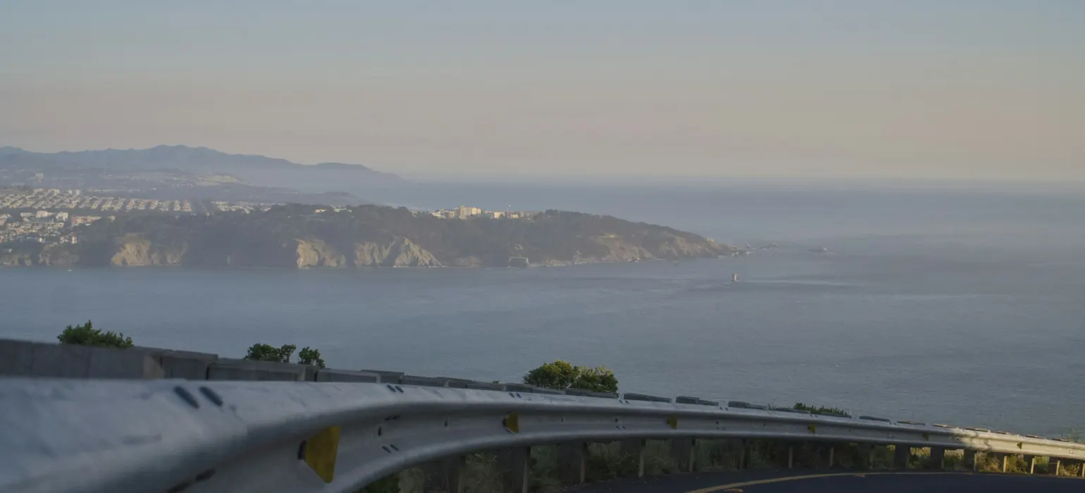 A curved road with a view of the ocean