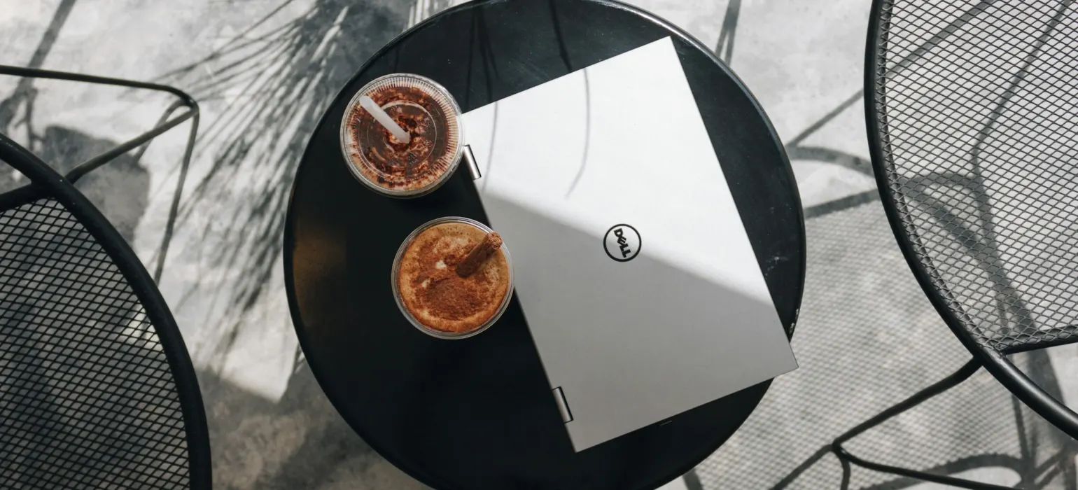 A table with two cups of coffee and a book on it