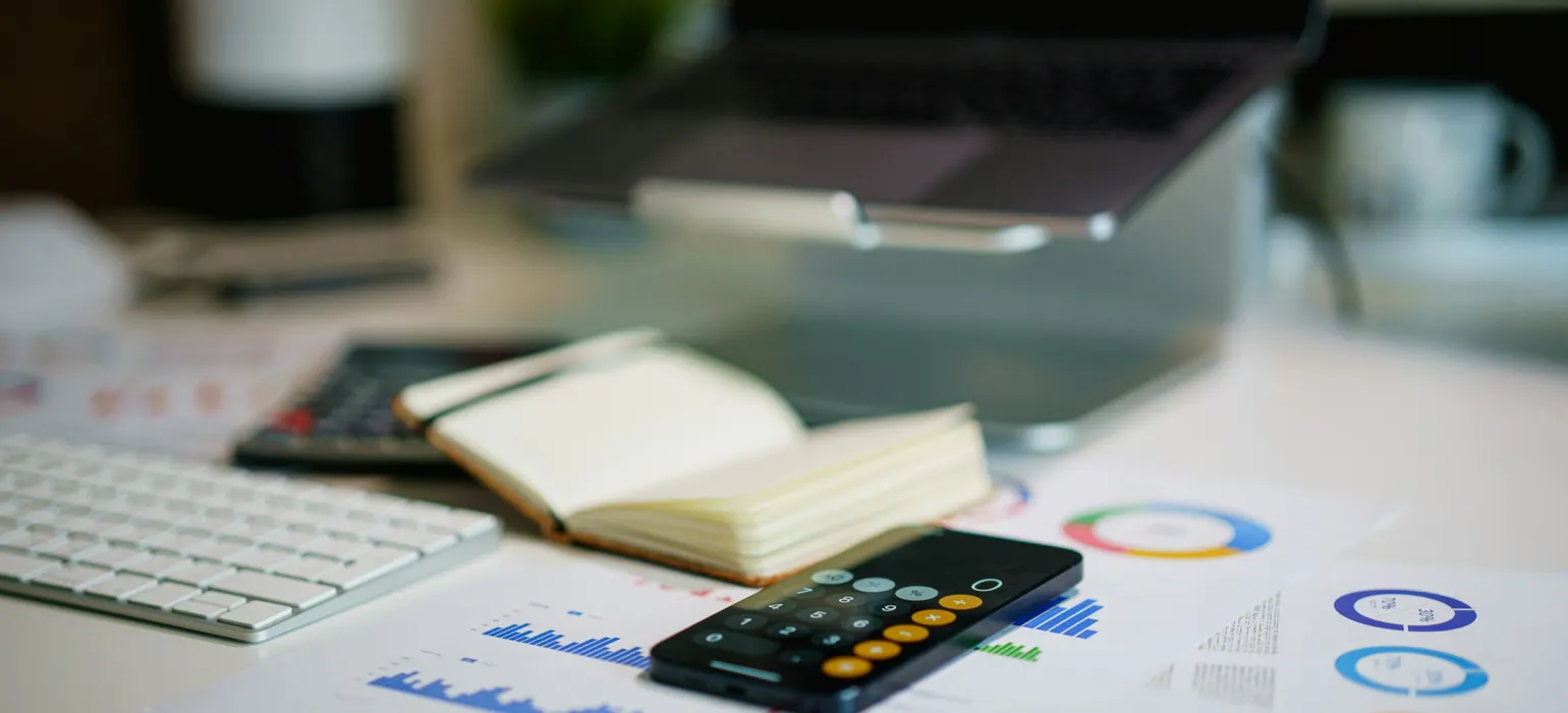 Office desk with smartphone and financial charts