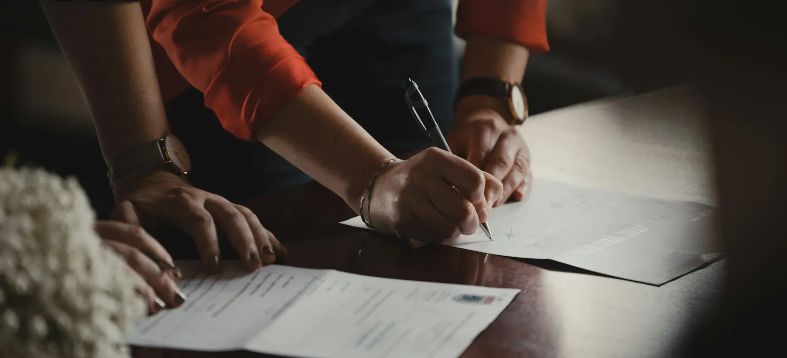 People reviewing and signing documents at a table