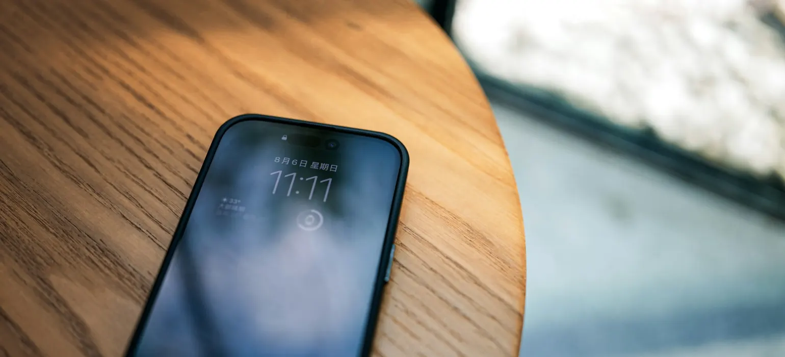 A cell phone sitting on top of a wooden table