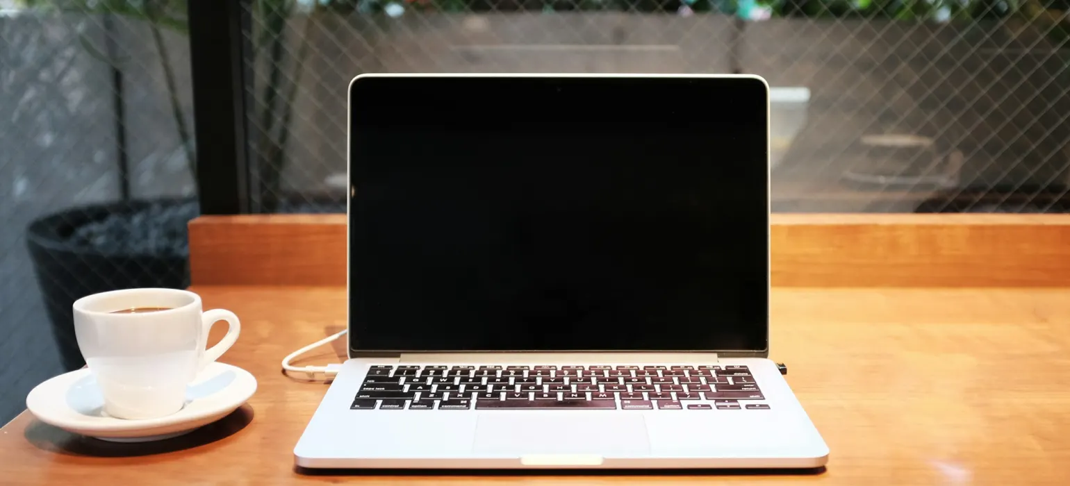 Laptop computer beside coffee mug