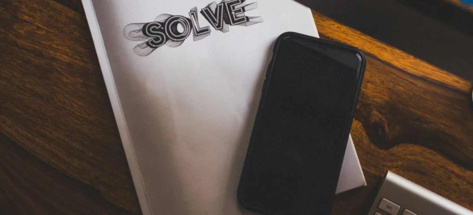 Black phone on top of white notebook
