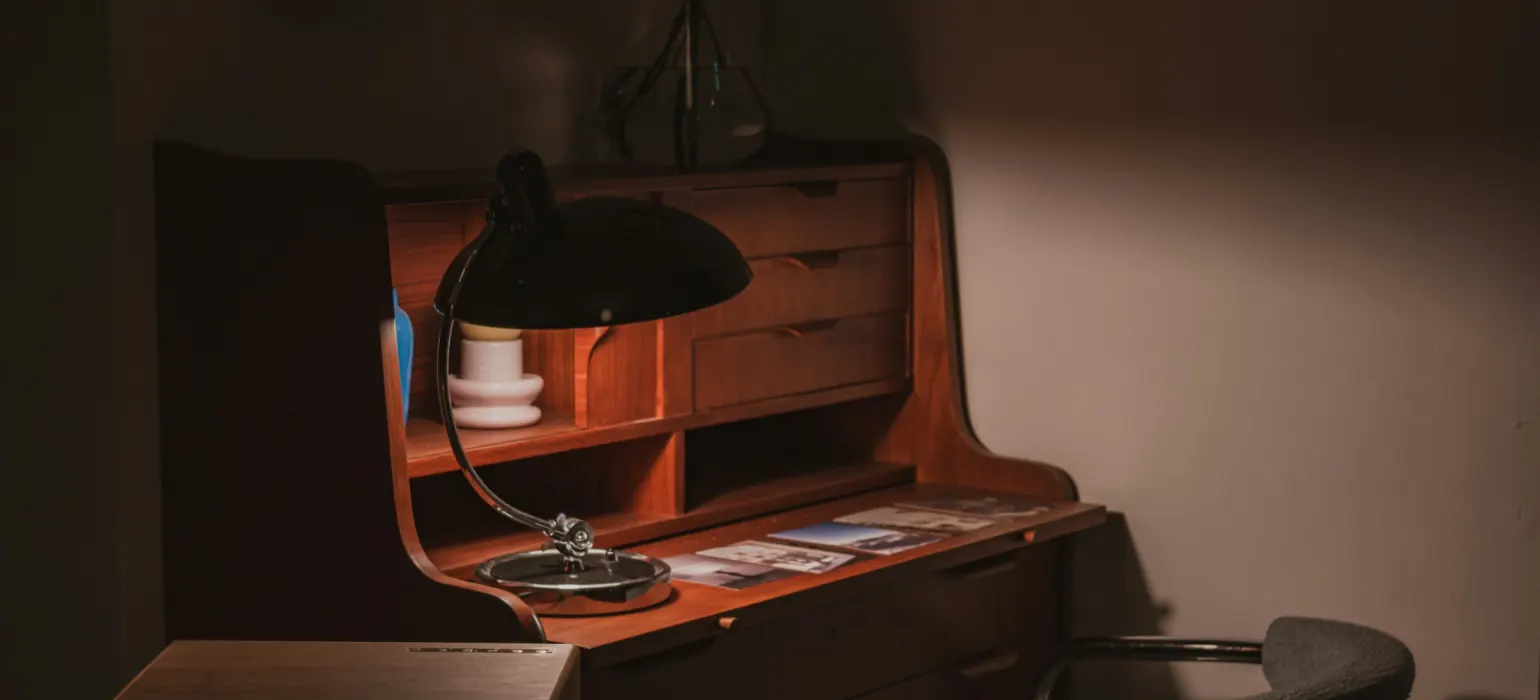 A vintage desk with a lamp and chair