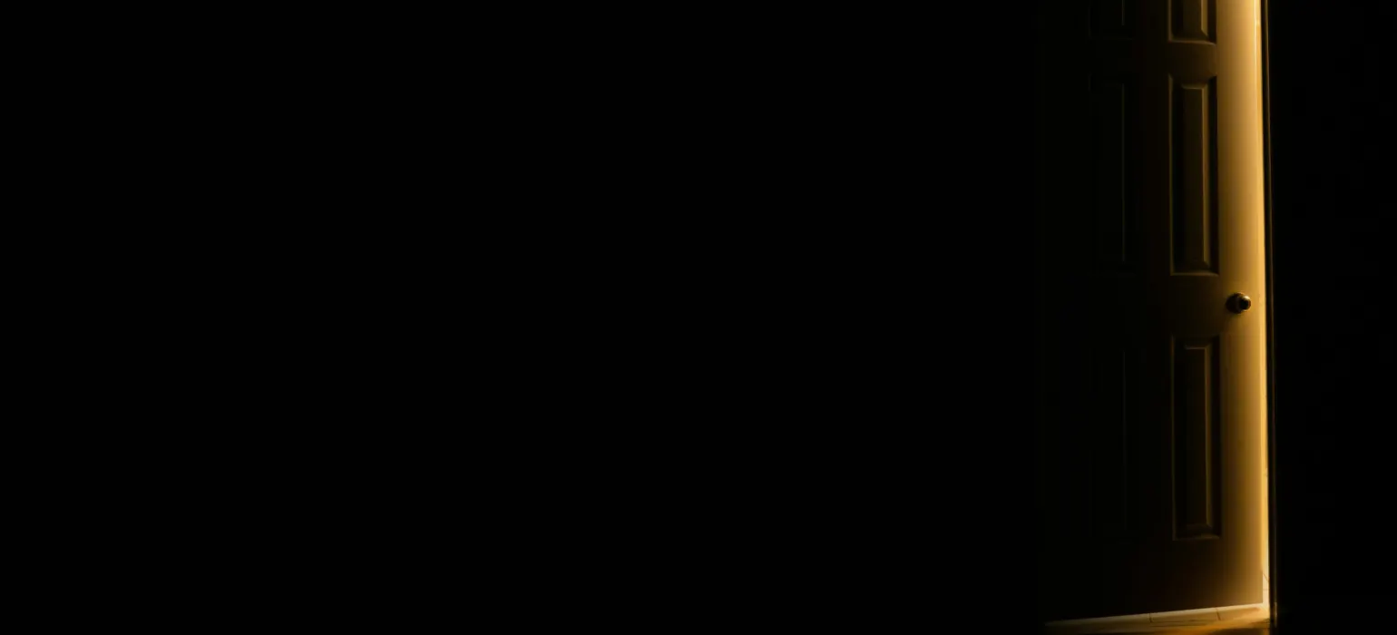 An open door in a dark room with light coming in