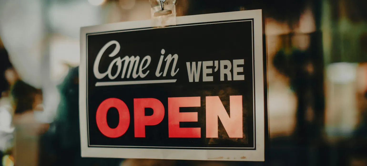 A sign on a shop door that reads come in, we're open