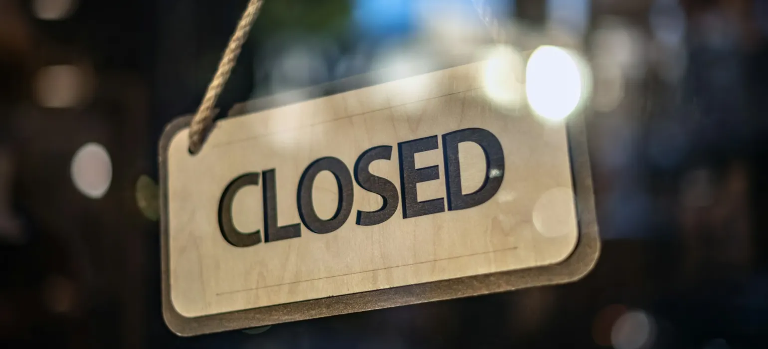 A closed sign hanging from a glass door