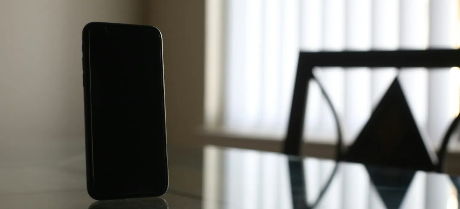 Black smartphone on brown wooden table
