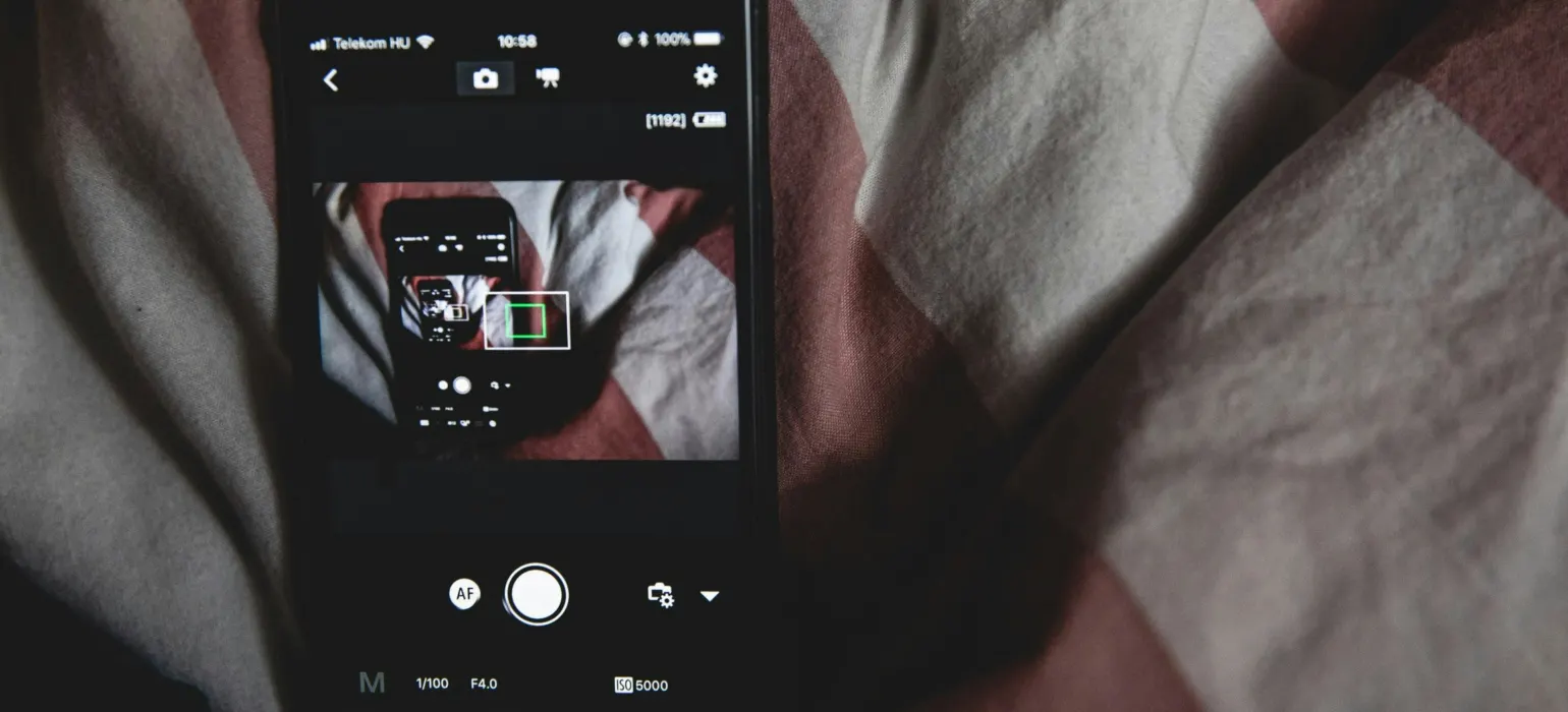 Black Android smartphone on bed sheet