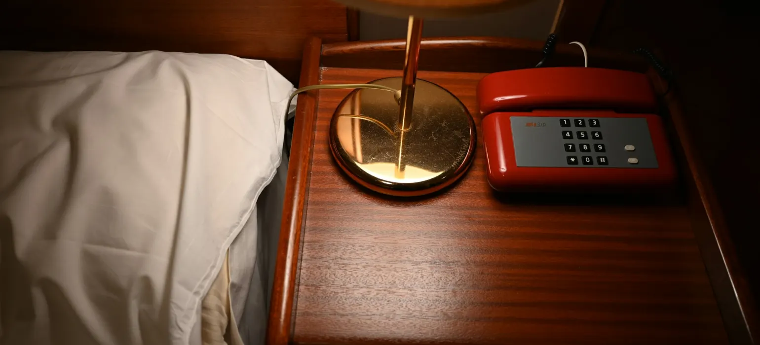 A table with a lamp and a phone on it