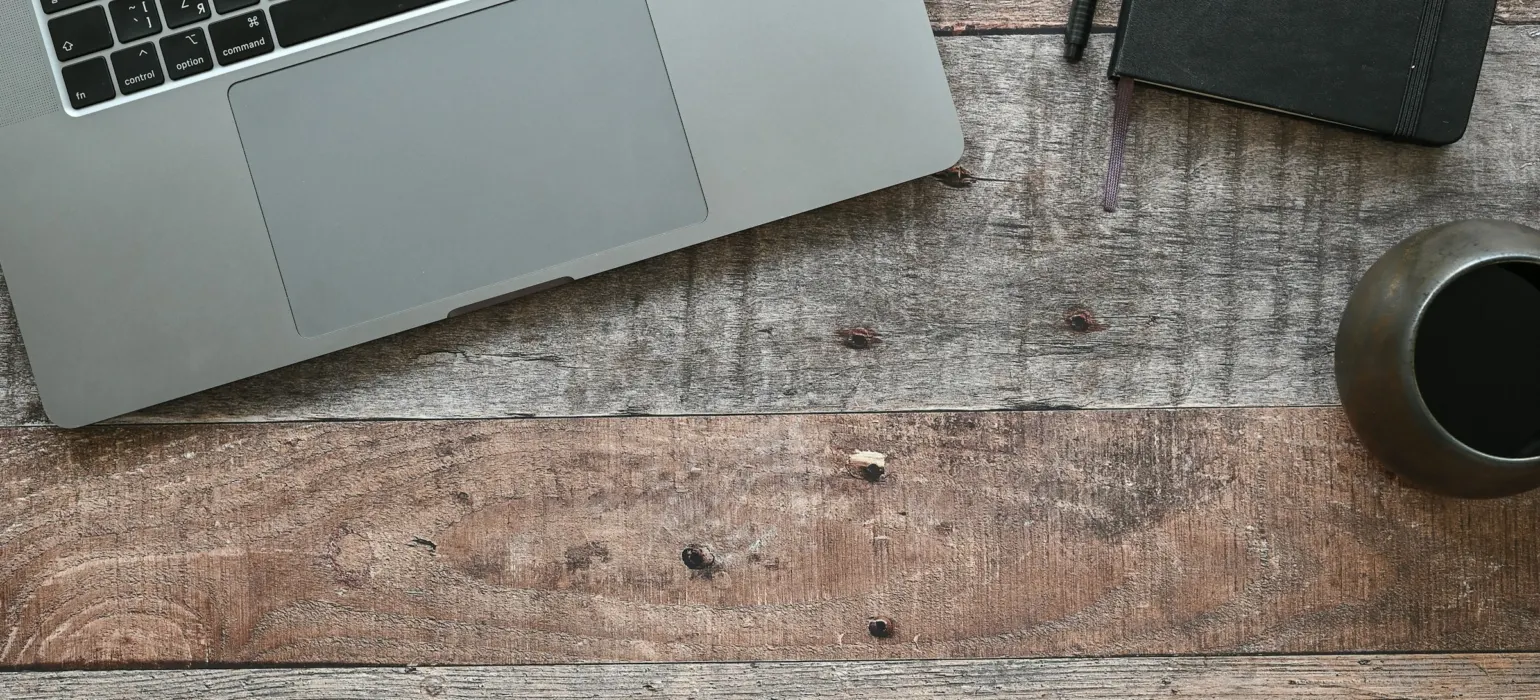 A laptop and a cup on a table