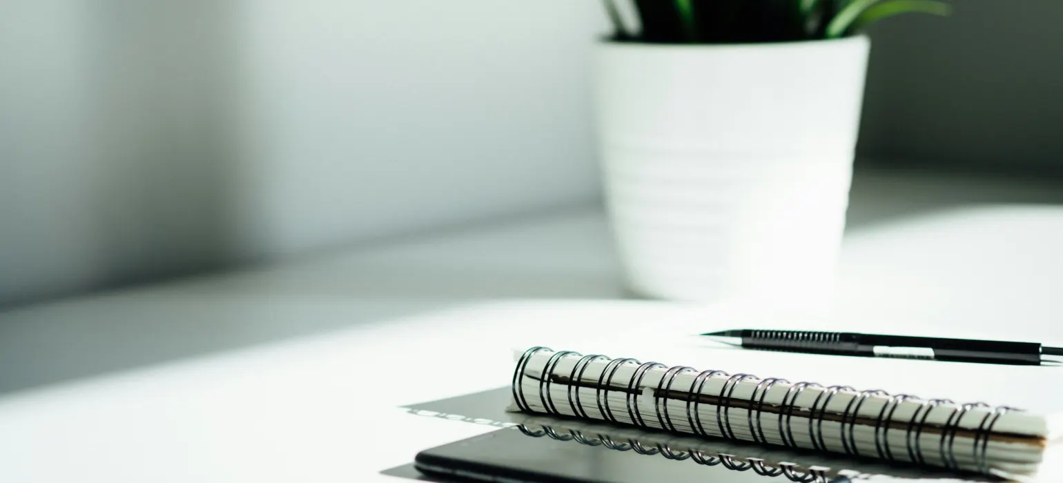 Pen, notebook, and smartphone on table