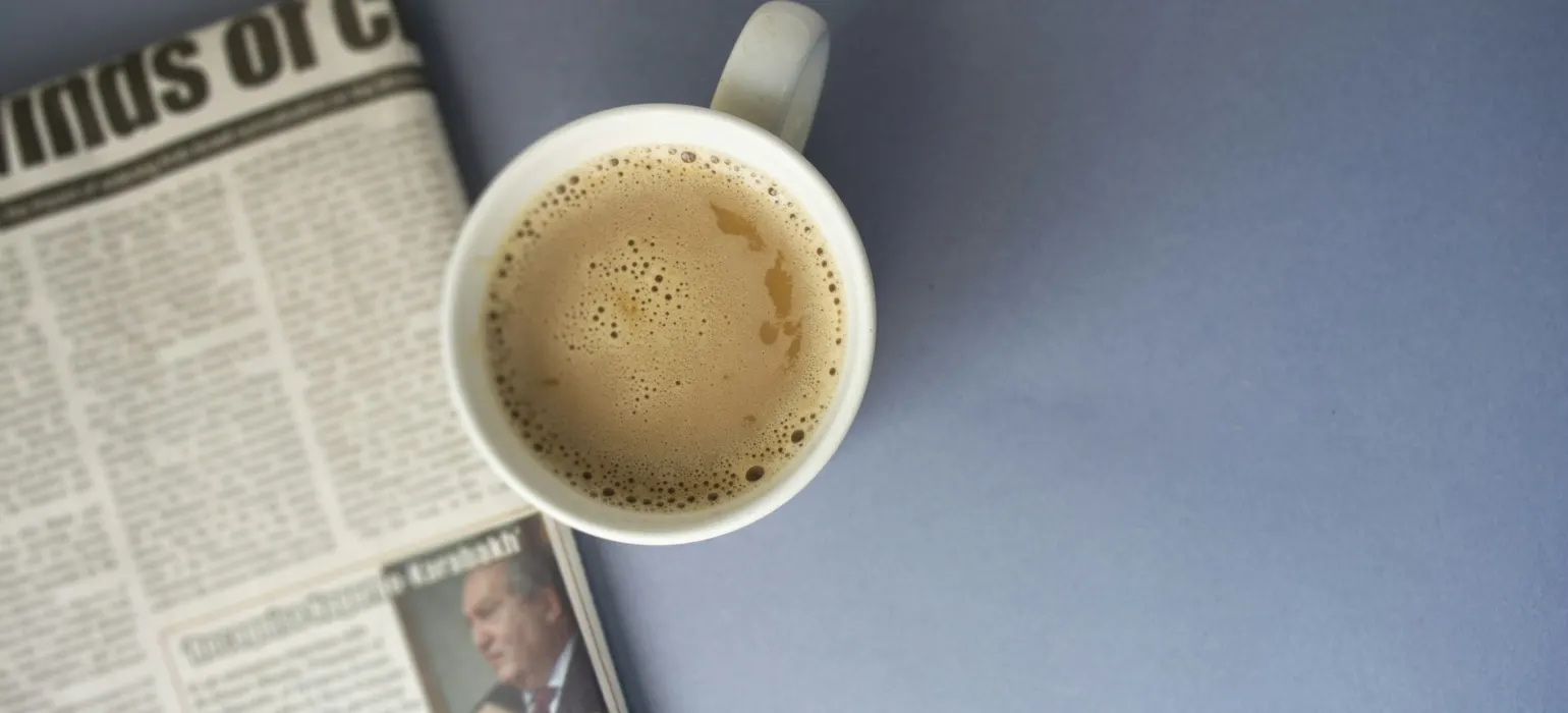 Newspaper and a cup of coffee on a table