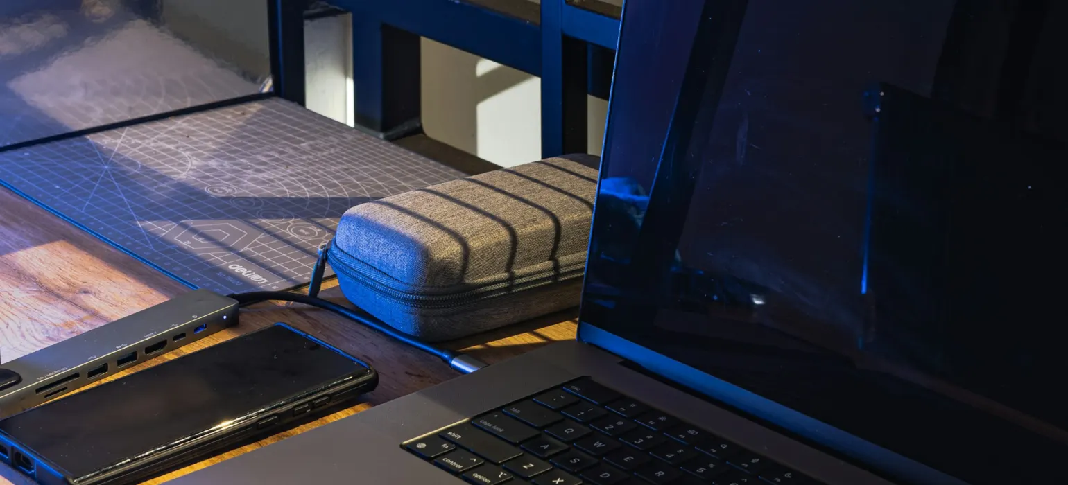 Laptop, phone, and charger on a wooden desk