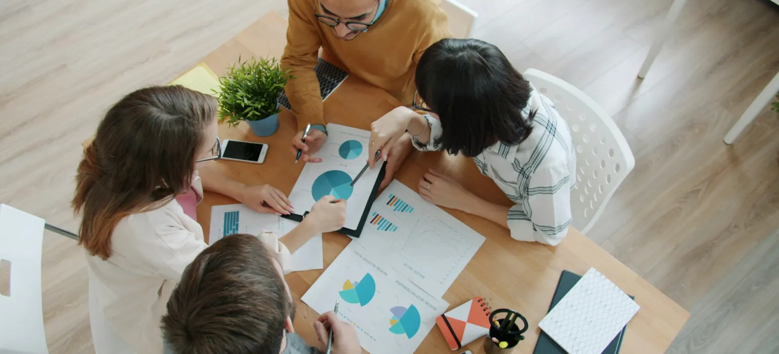 Colleagues reviewing charts around a table