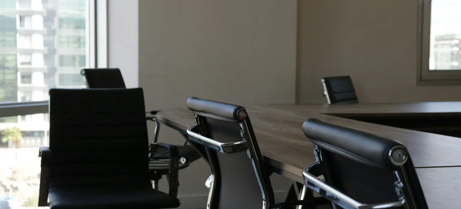 Empty office chairs around a meeting table