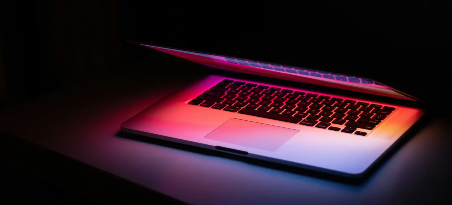 Laptop glowing in a dark room