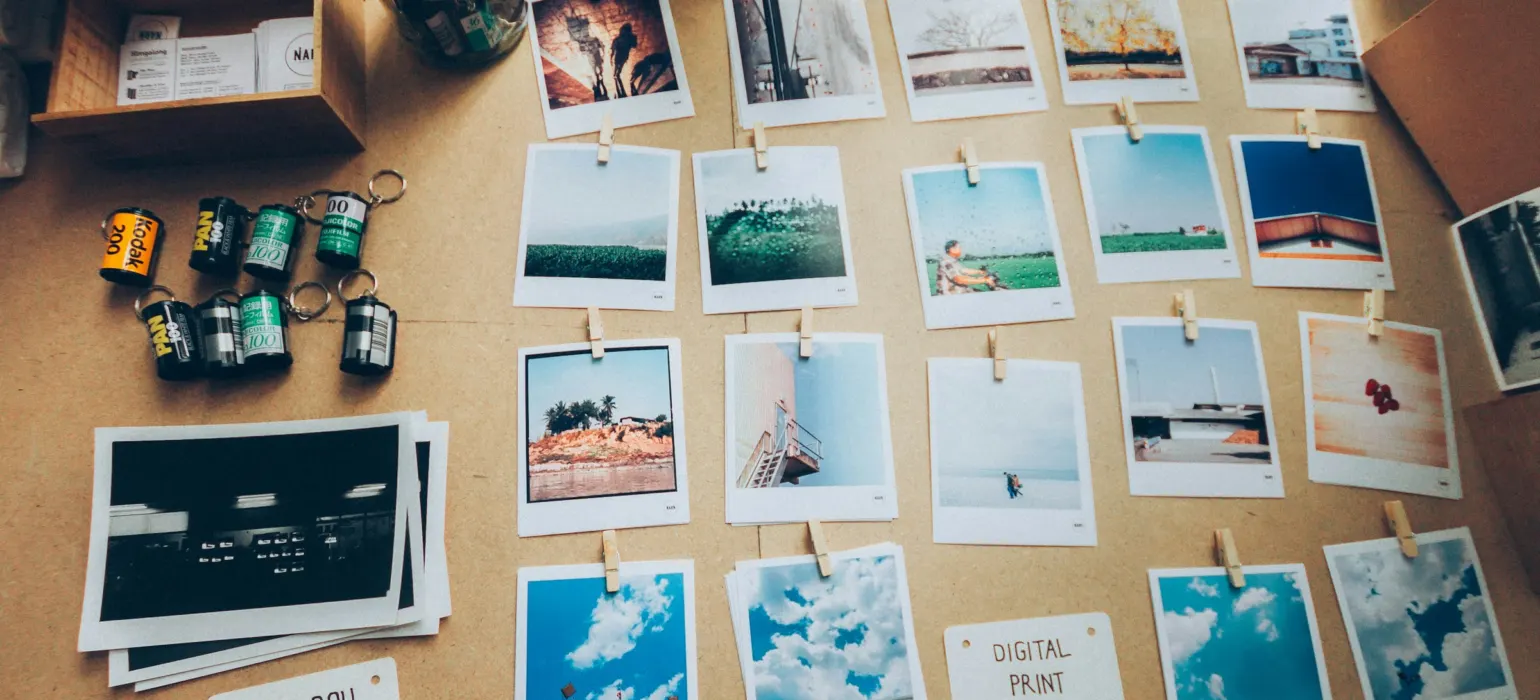 Printed photographs pinned to a corkboard