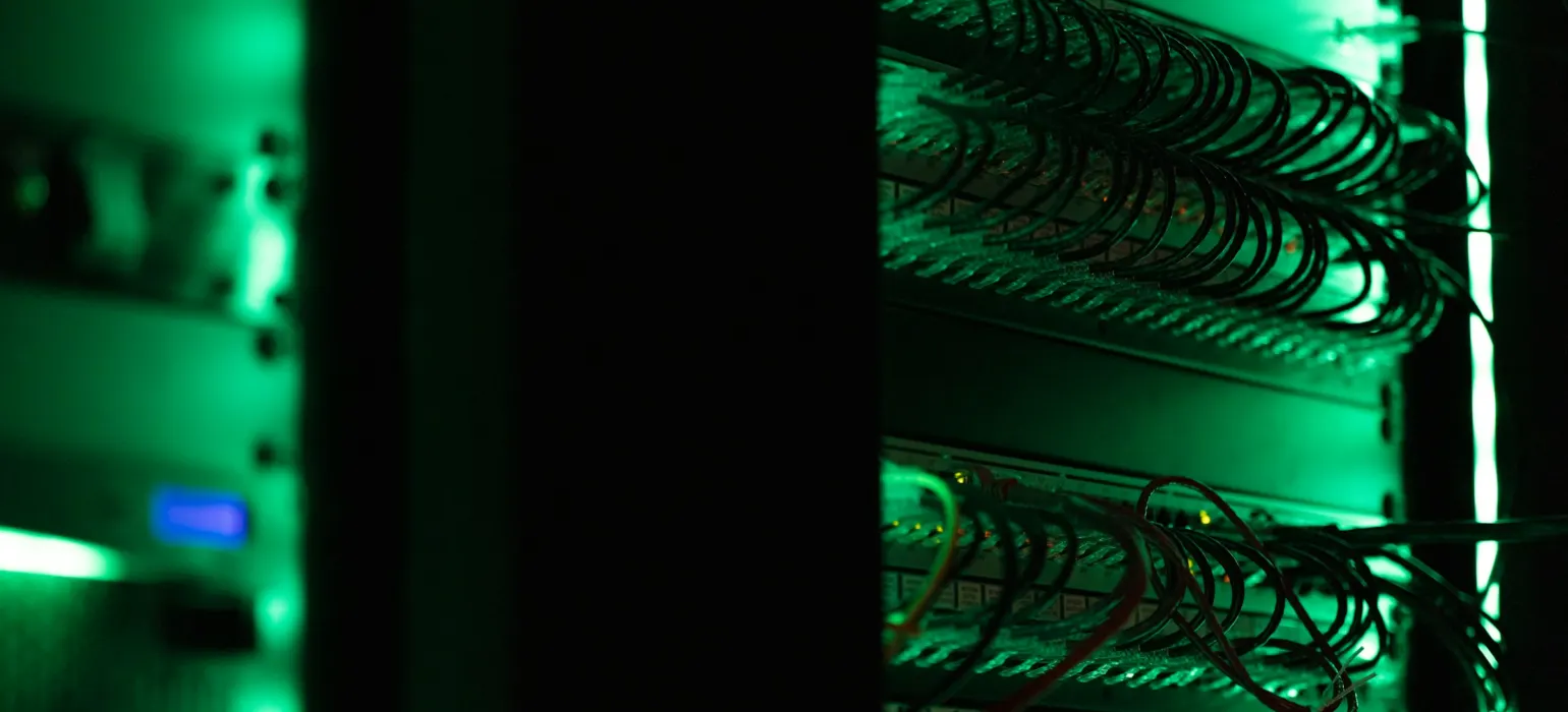 Server racks lit green in a dark data center