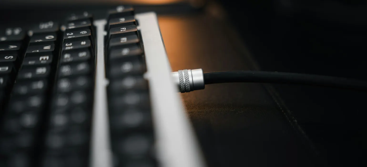 Close-up of a keyboard with a cable plugged in