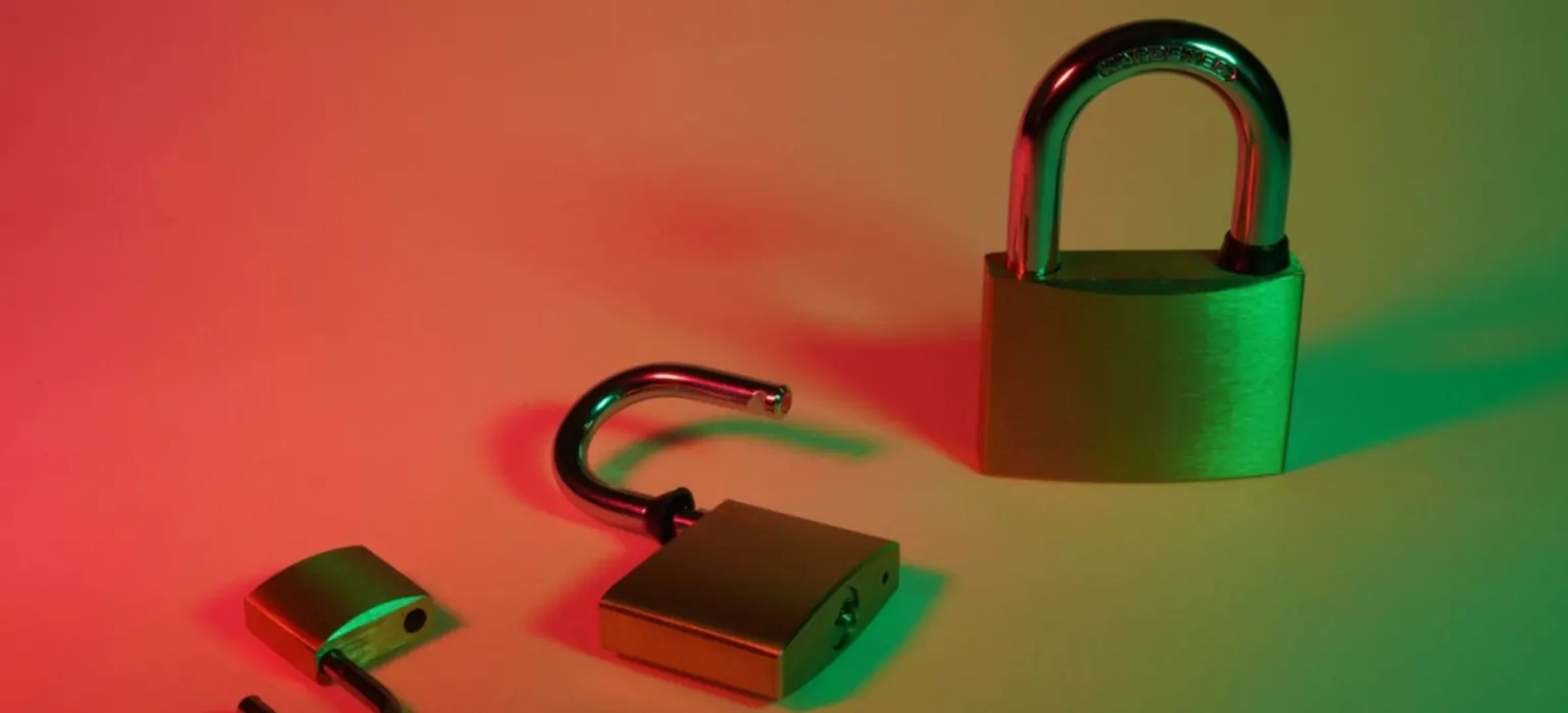 Three padlocks, two of them open, under red and green light