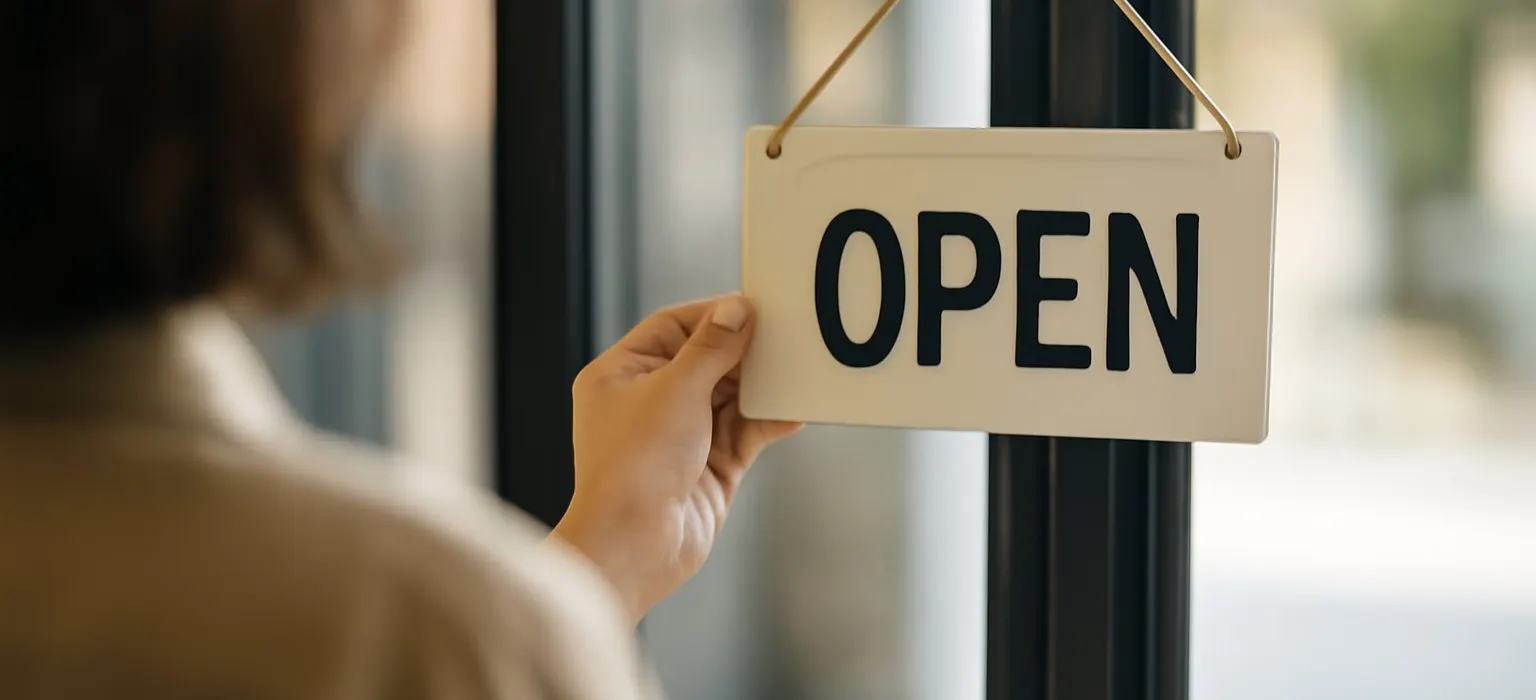 A small shop's glass front door with an open sign hanging inside