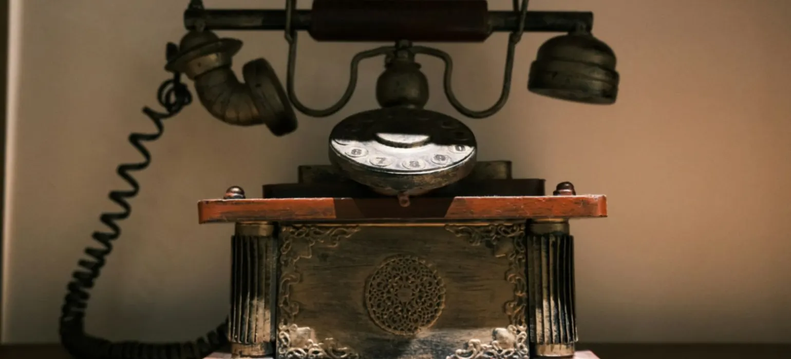 Antique rotary telephone on a wooden surface