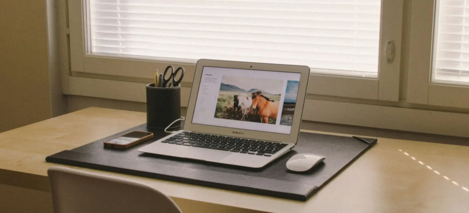 Turned on laptop on beige wooden desk