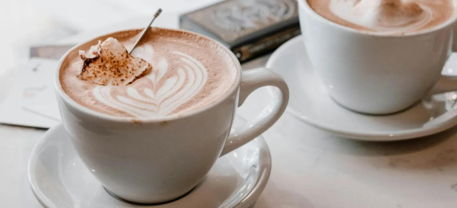 Two white ceramic cups with saucers