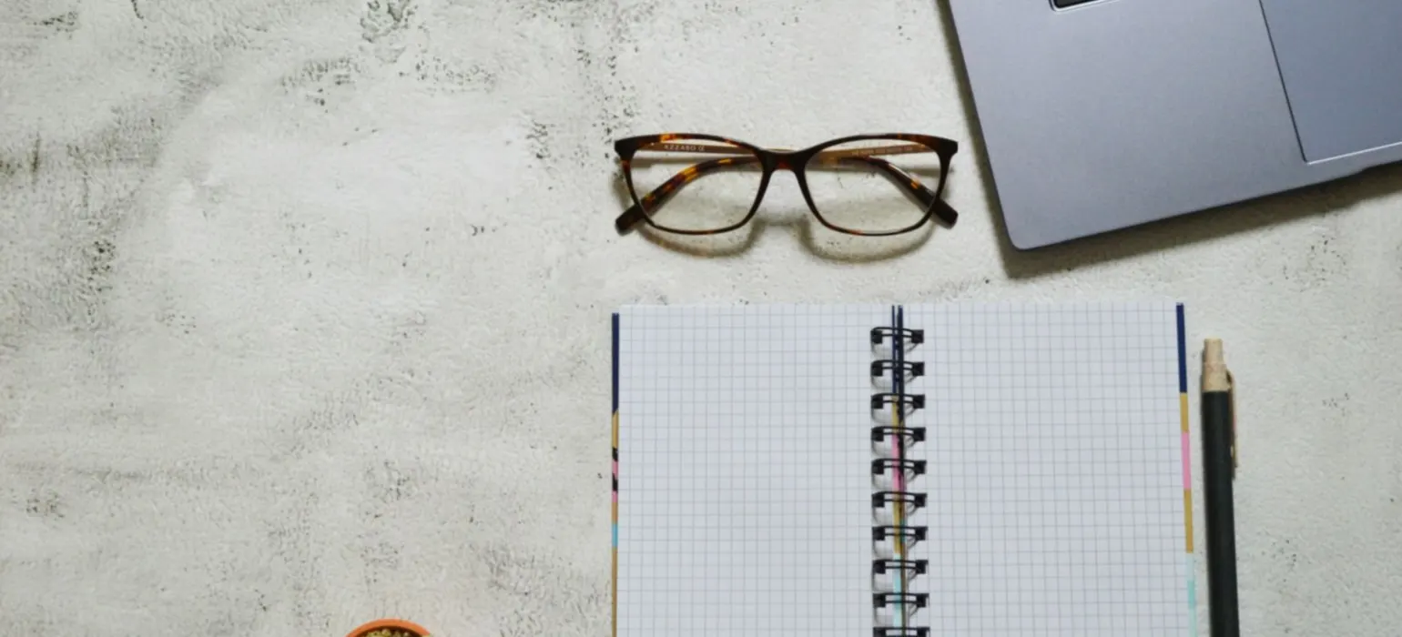 Black framed eyeglasses on white notebook