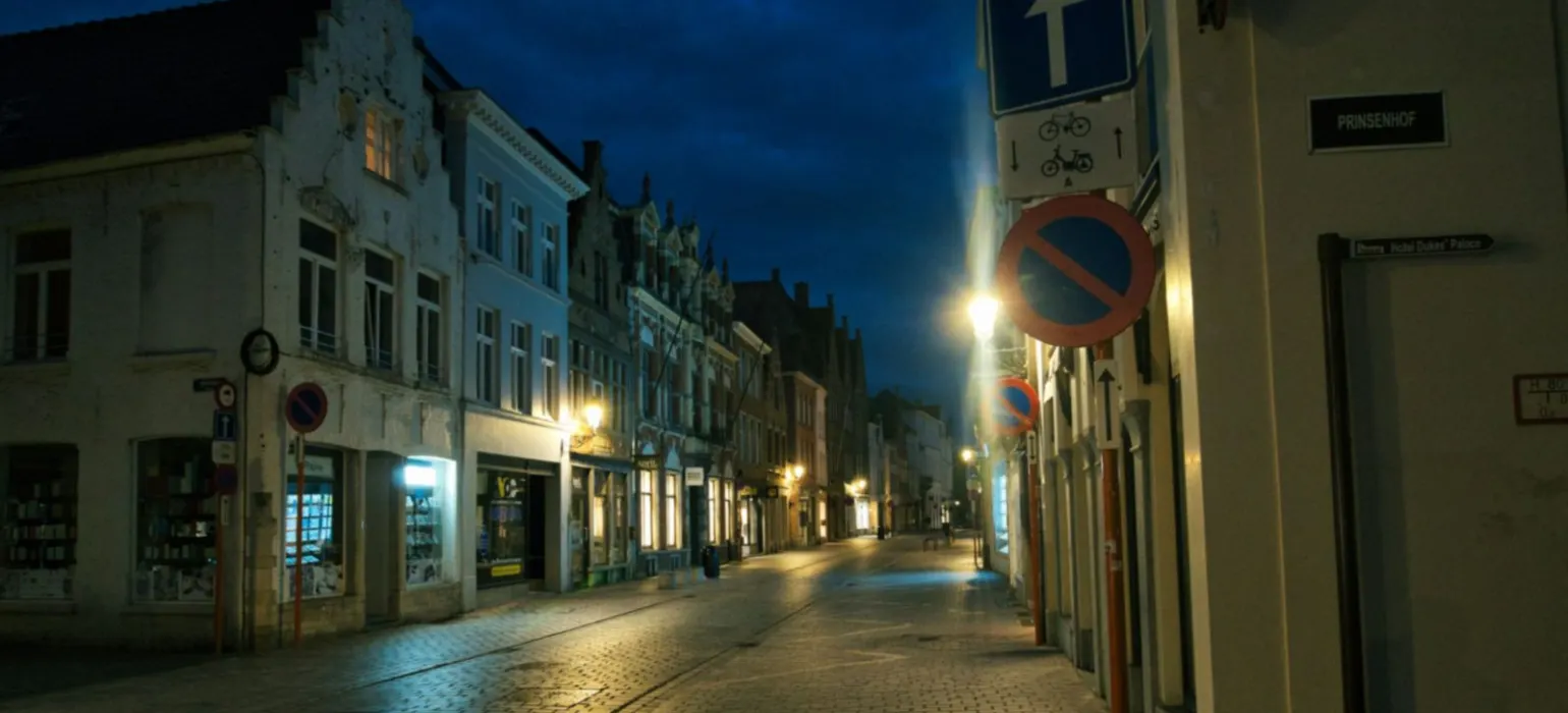 Empty european street at night with illuminated buildings
