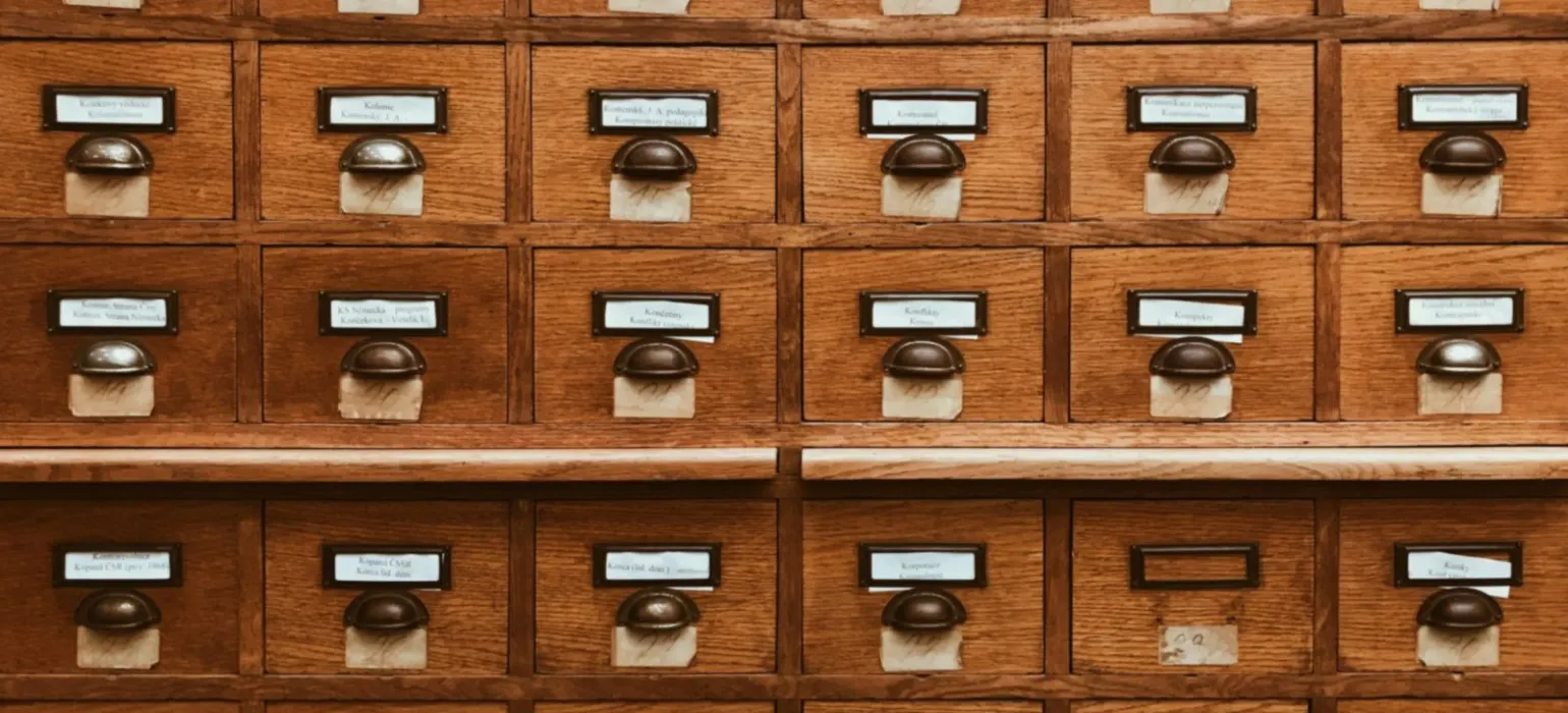 Rows of small wooden catalog drawers with labels