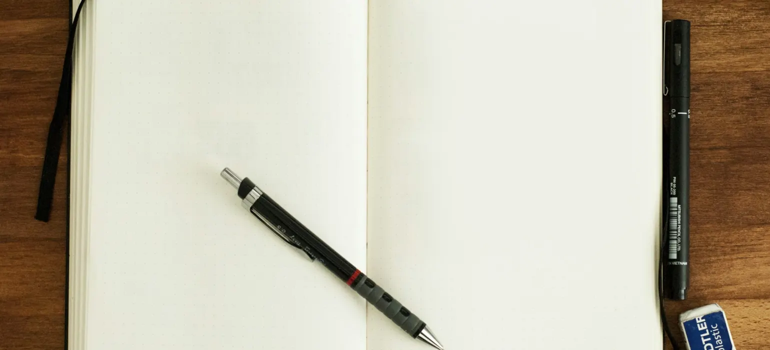 Black and silver retractable pen on blank book
