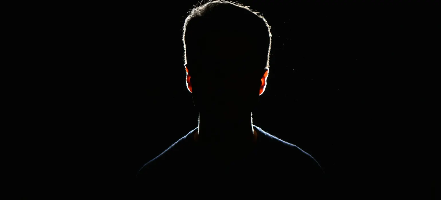 Silhouette of a person against a dark background