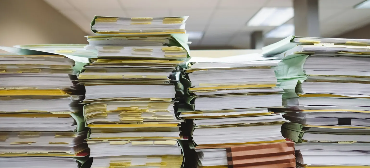 Tall stacks of paper records and file folders