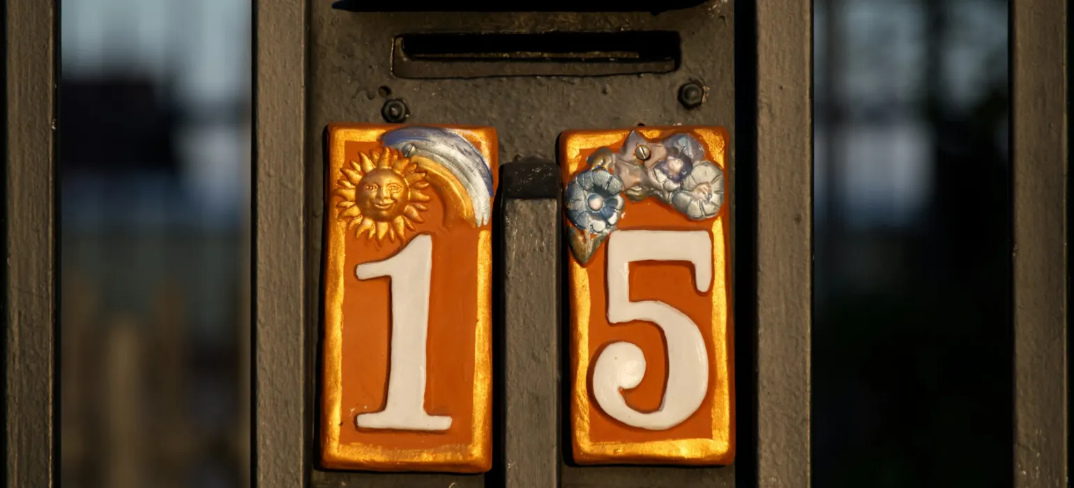 A house number sign on a front gate