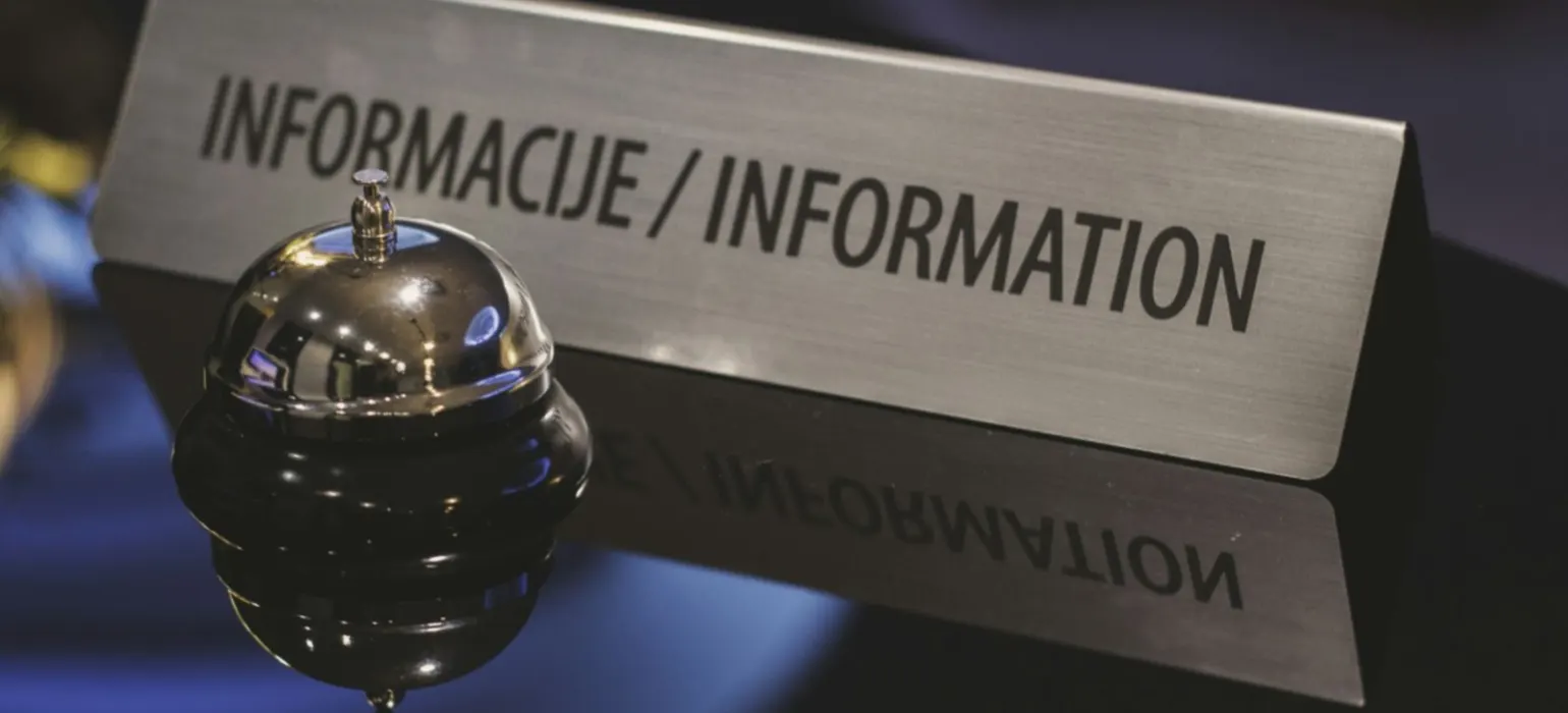 A service bell in front of an information desk sign