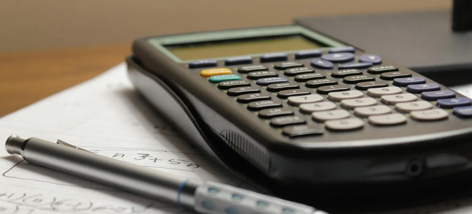 Calculator and pen on a sheet of paper