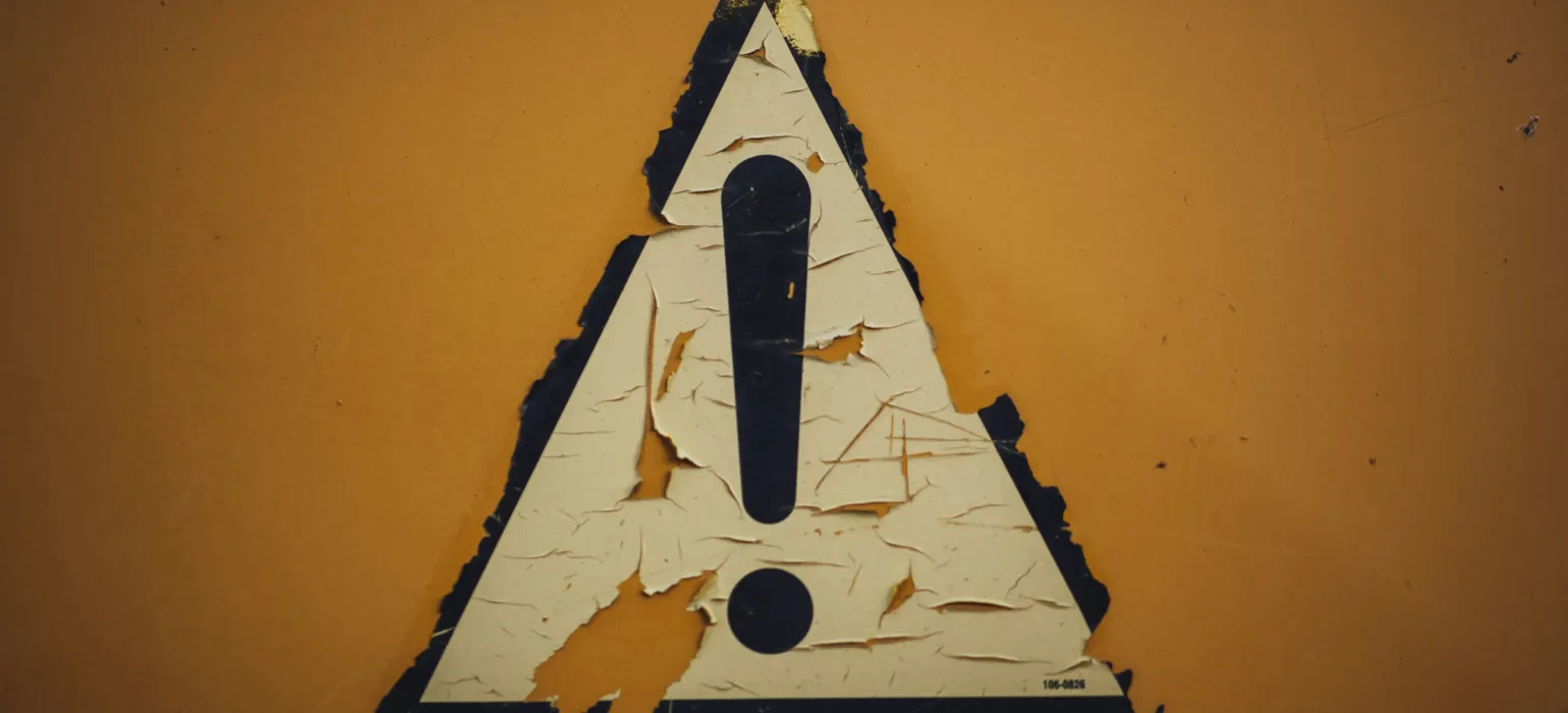 Weathered warning sign with an exclamation mark