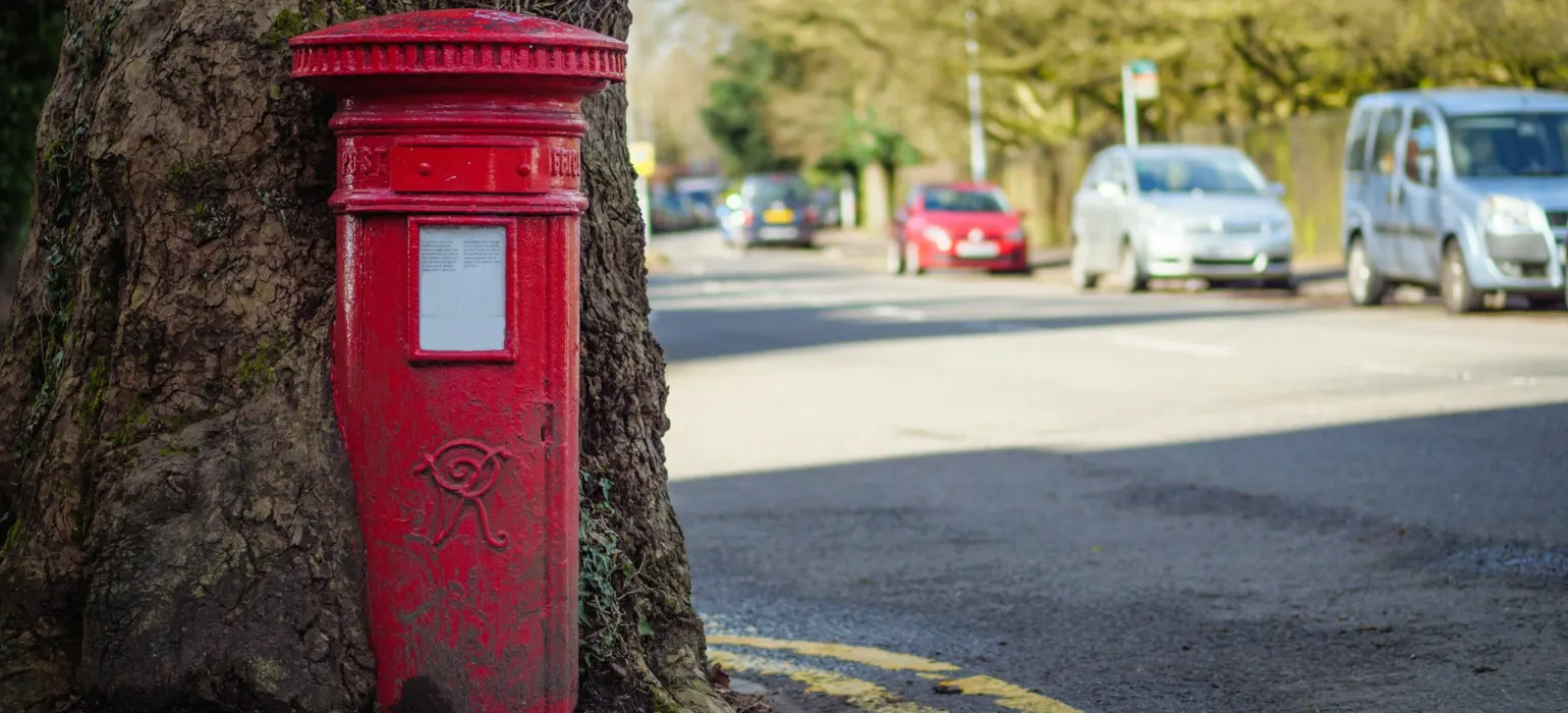 Red mail box on road during daytime