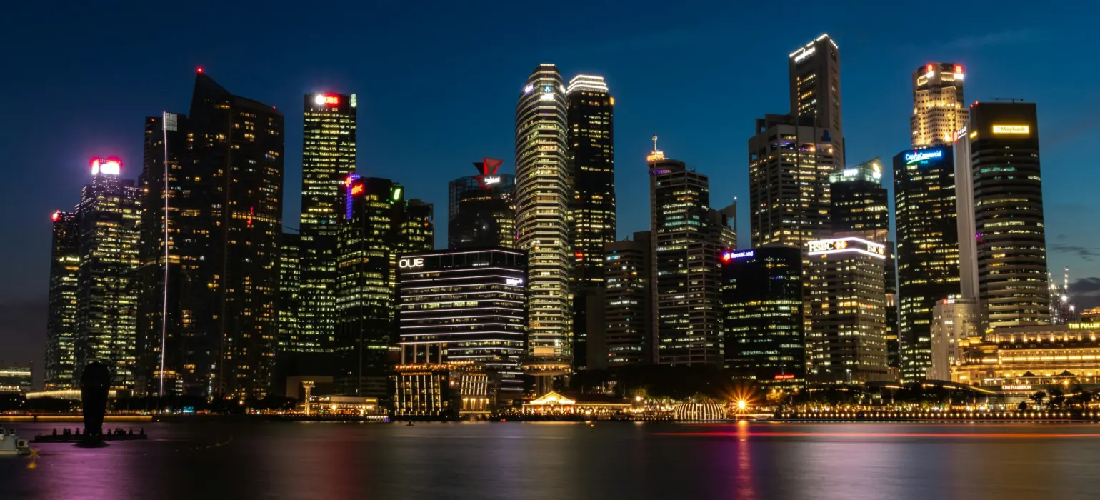 Cityscape near the body of water with lights turned-on during nighttime