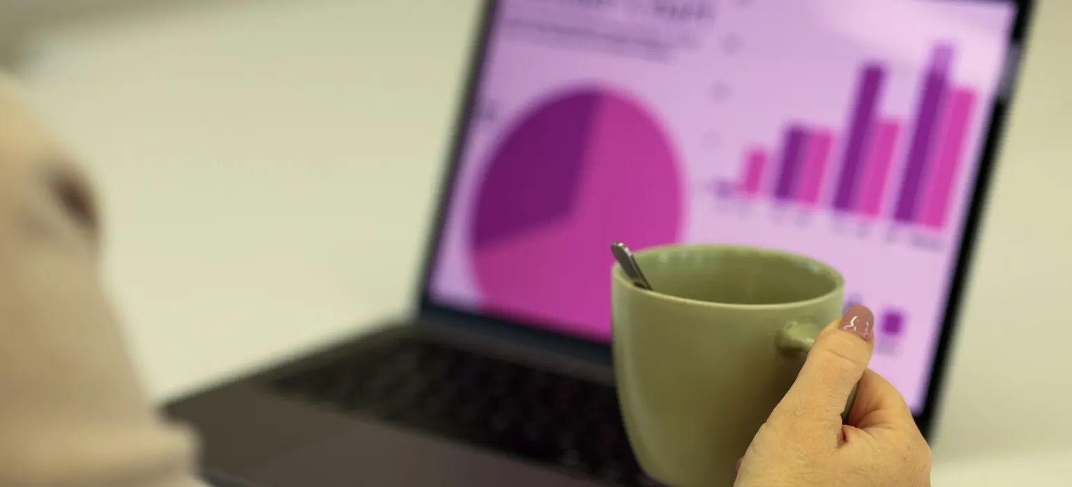 Person working on a laptop with a cup of coffee