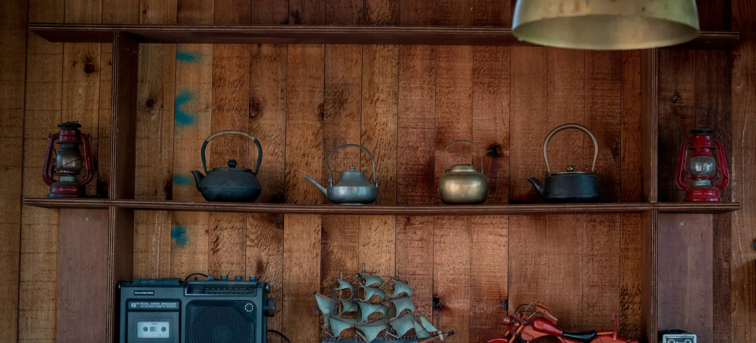 Wooden shelves display teapots, radio, and motorcycle