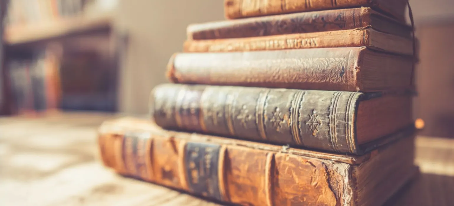 Stack of six brown hardbound books