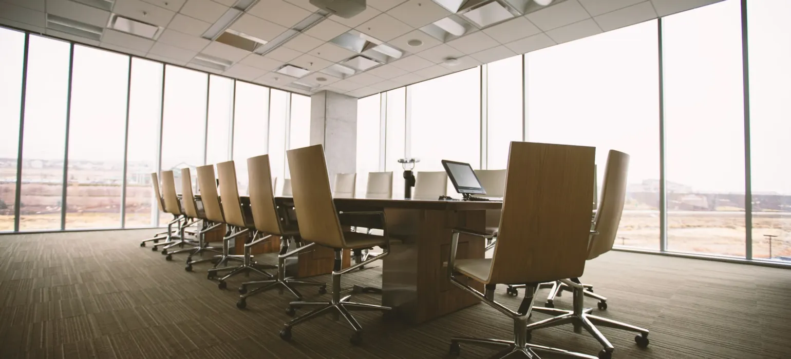 Oval brown wooden conference table and chairs inside conference room
